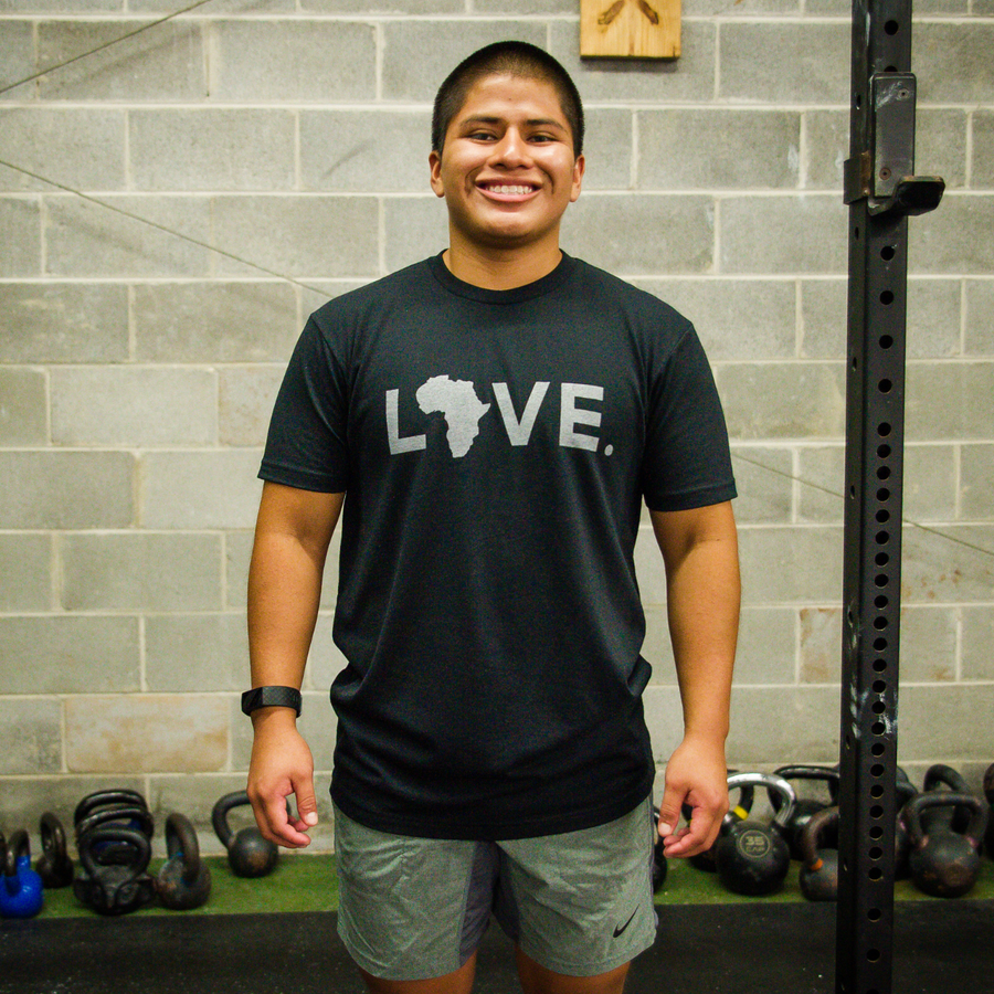 Young man wearing black and grey love africa tshirt in a Crossfit gym